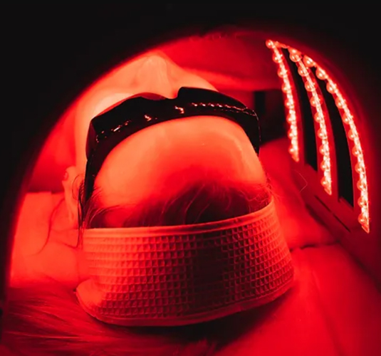 A woman under LED light therapy