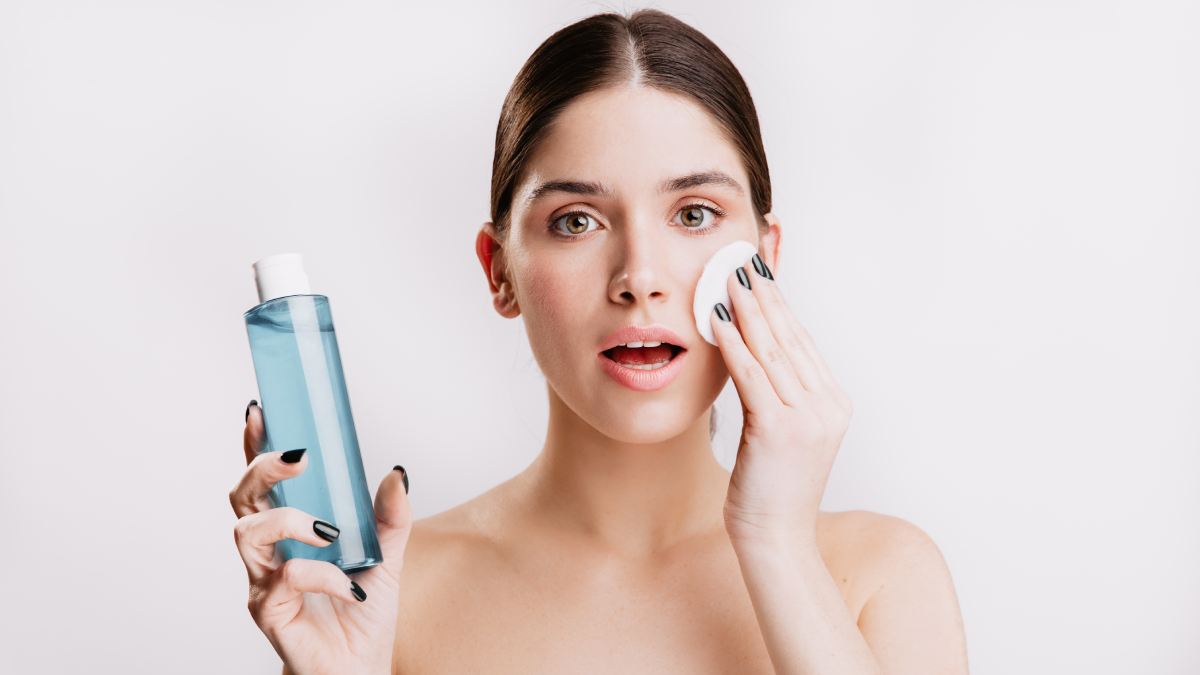Pretty girl cleansing face impurities using facial toner