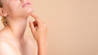 Young woman touching her chin and neck